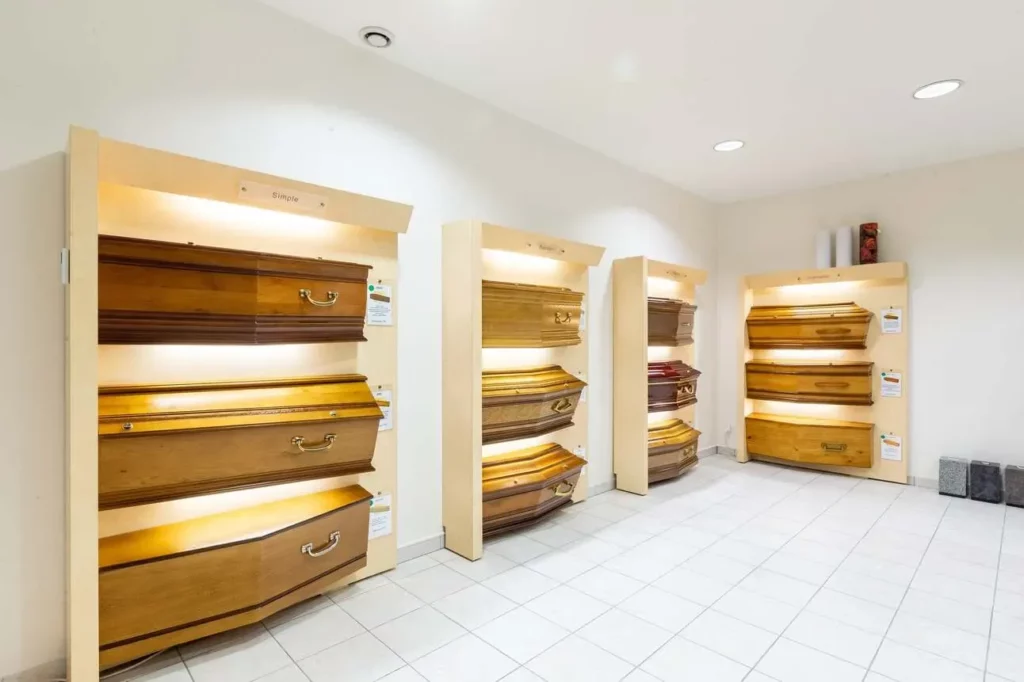 Modèles de cercueils en bois présentés dans un salon d'exposition.